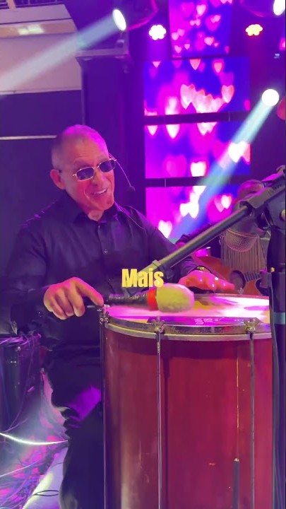 Percussionista do Fala Garoto tocando surdo sob luzes coloridas